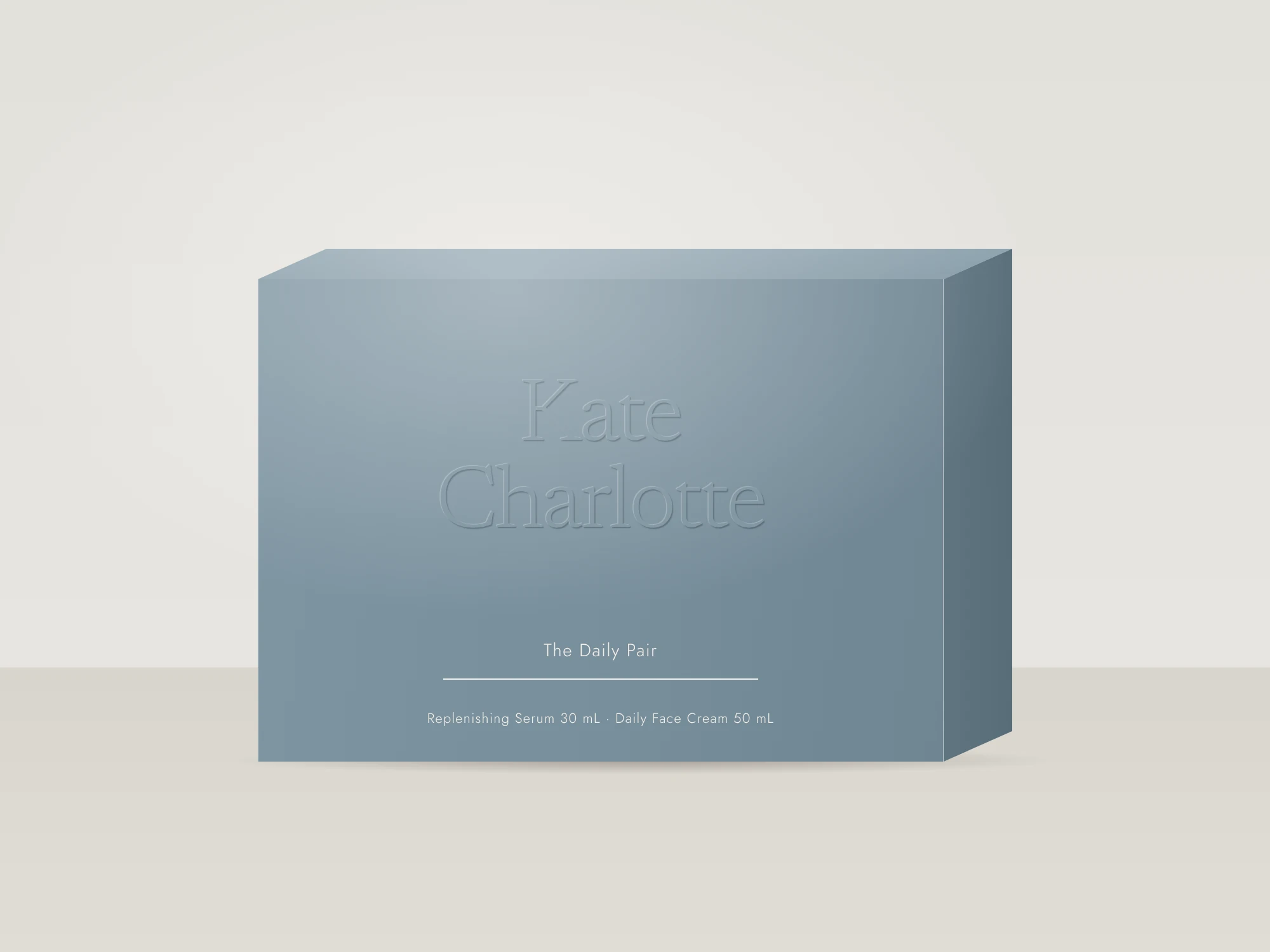 The Daily Pair gift set in Coastal Slate, with a blind-embossed wordmark: Replenishing Serum and Daily Face Cream