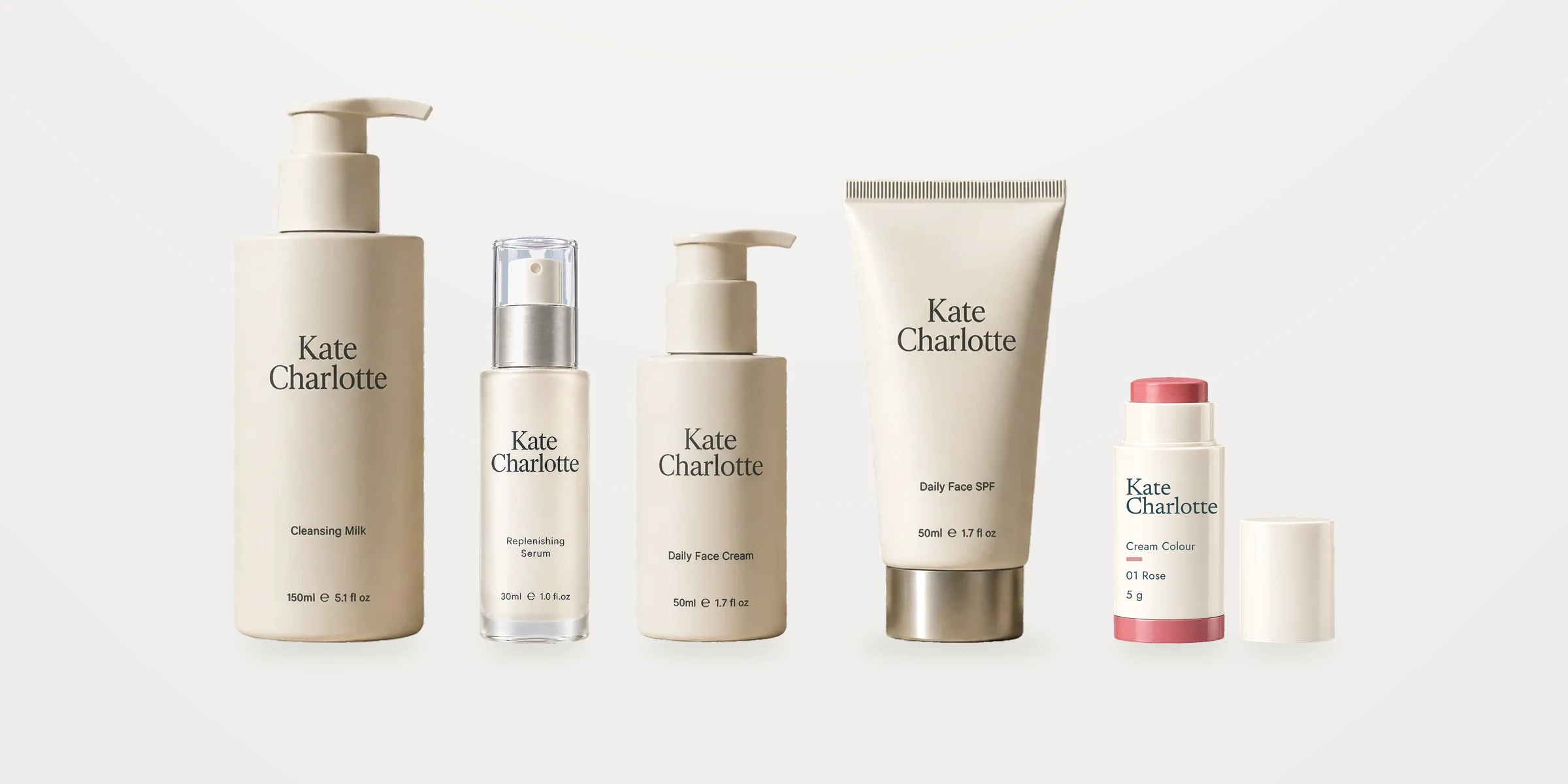 The five Kate Charlotte products in a row on a quiet ivory ground: Cleansing Milk, Replenishing Serum, Daily Face Cream, Daily Face SPF and Cream Colour