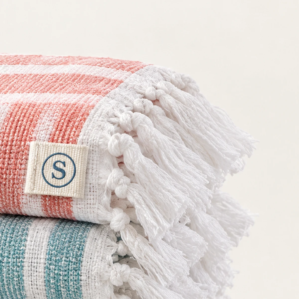 The circled S tab, folded and stitched into the edge of a striped Turkish towel